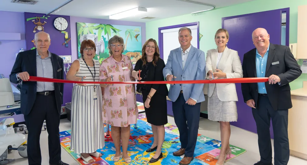 Seven people gathered in a colorful Smilezone area to cut the ceremonical ribbon.