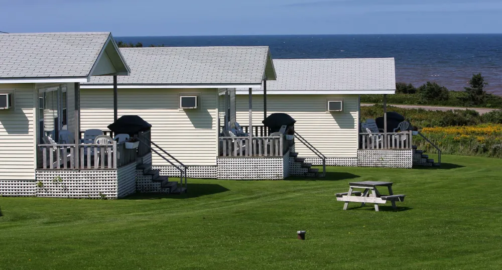 Three white cottages at waterfront in summer