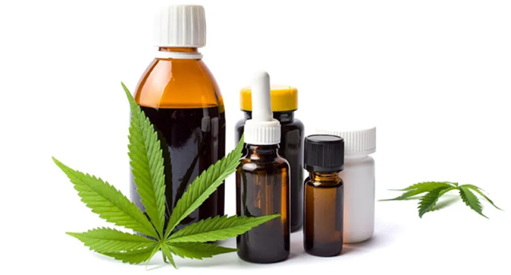 Various cannabis products pictured with a cannabis leaf in the foreground and background
