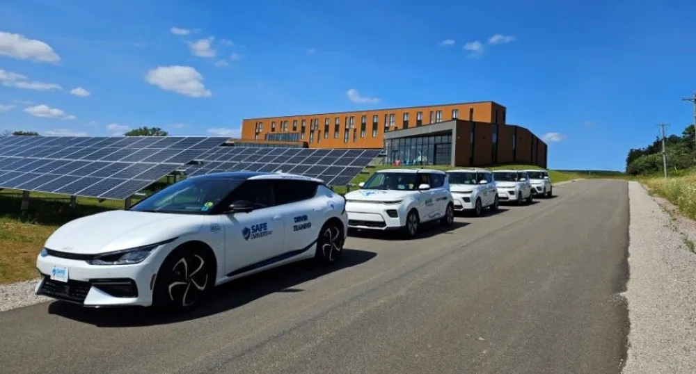 EVs parked in front of solar panels.
