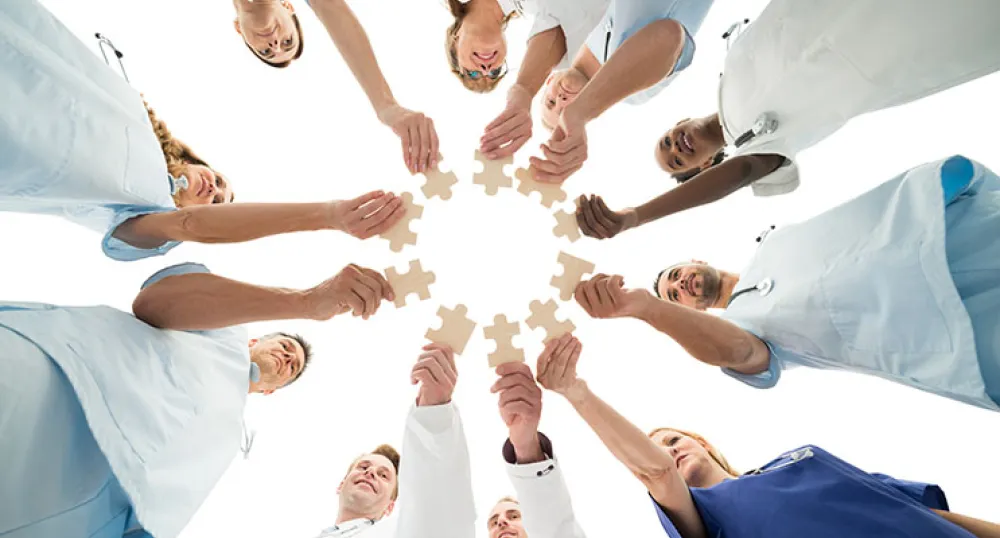 health team standing in a circle with all hands in health team standing in a circle with all hands in