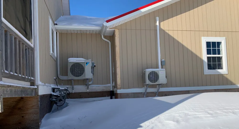 A picture of two outdoor heat pump units in winter