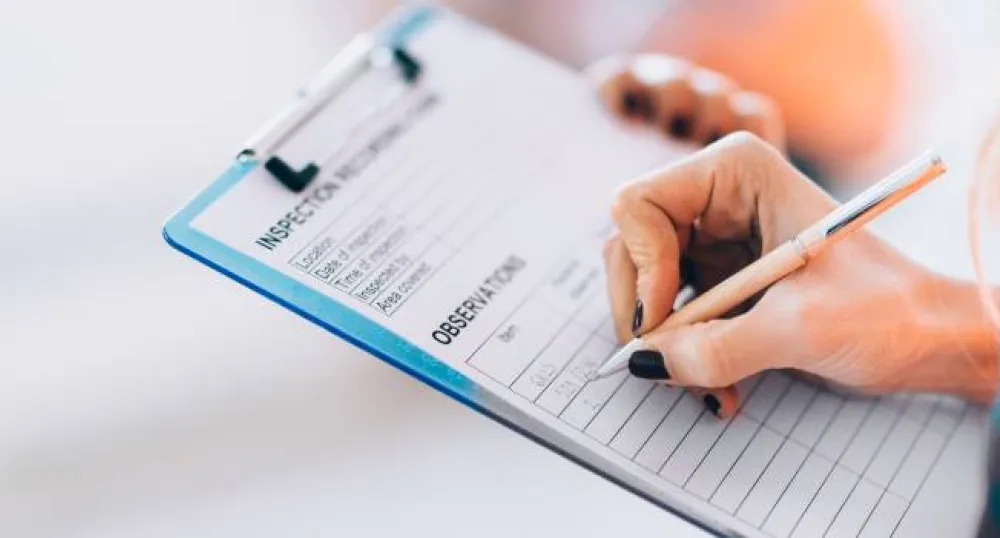person writing on a clipboard