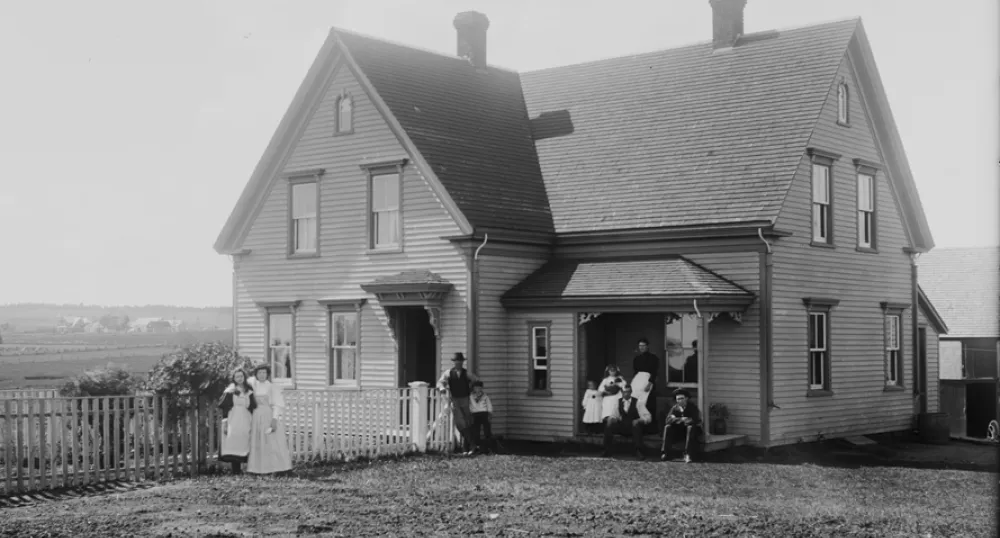 La maison Brehaut, à Alexandra, à l’Île-du-Prince-Édouard, vers 1890-1906 La maison Brehaut à Alexandra, à l’Île-du-Prince-Édouard, vers 1890-1906. On peut voir des membres de la famille prenant la pose sous le porche et devant la clôture, ainsi que le paysage rural en arrière-plan.