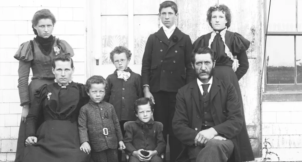Photo de la famille Judson en 1898 Famille constituée d’un homme, d’une femme et de six enfants prise en photo devant une maison