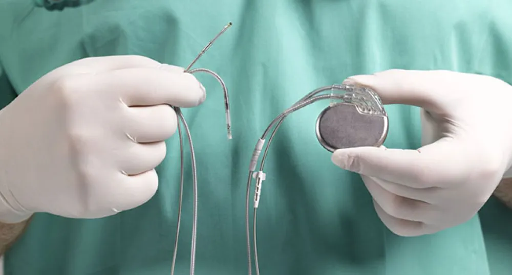 surgeon holding a pacemaker