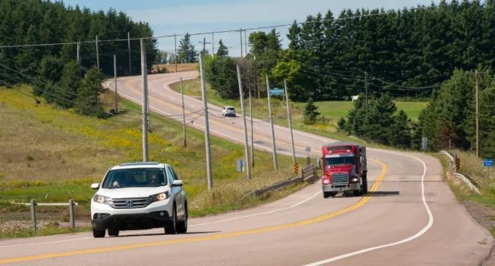 a car and a transport truck driving on a highway in Prince Edward Island