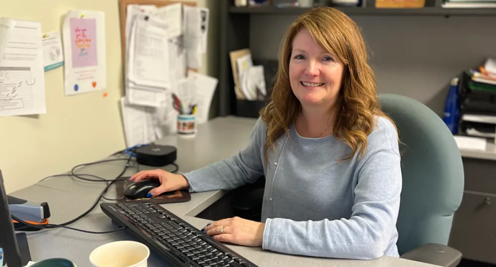 Social Worker Spotlight: Cheryl Jamieson image of a person siting behind a work desk in an office with a hand on a computer mouse