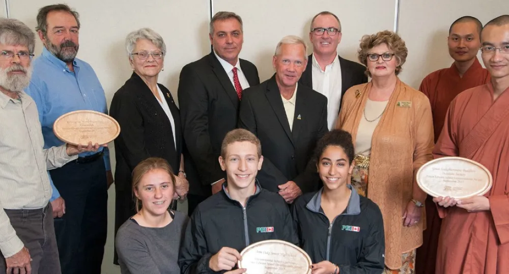 Islanders honored for protecting our environment Photo shows a group of people and three are holding plates representing the three environmental awards.
