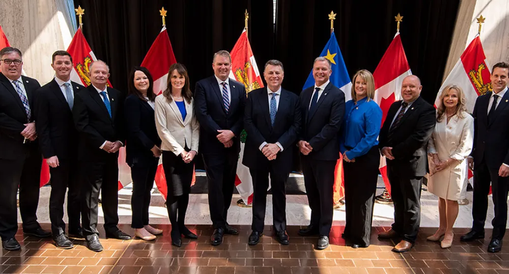 Premier King and new Cabinet members stand in front of PEI and Canada flags