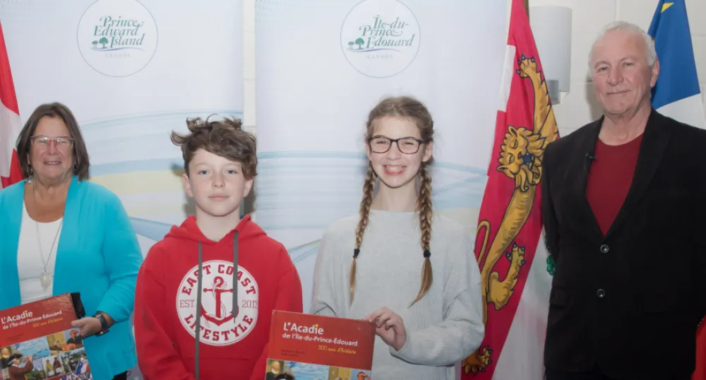 Linda Lowther (left) and Georges Arsenault, co-authors of the book L’Acadie de l Île-du-Prince-Édouard: 300 ans d’histoire, stand with students from École St-Augustin at the book's recent launch