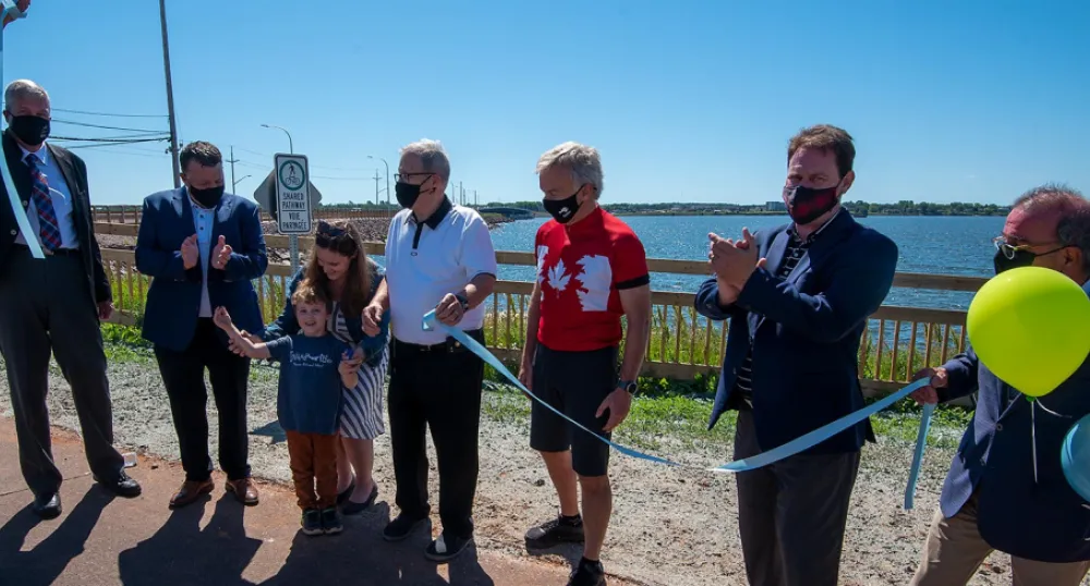 A number of people line up in front of the Hillsborough Bridge for the ribbon cutting to open the active transportation lane