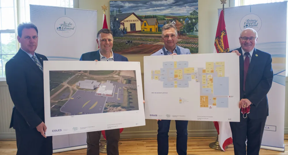 image of four people holding sketches of a future building