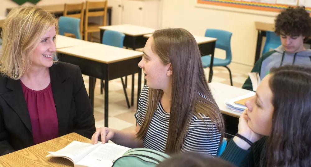 Birchwood teacher Frances Ann Squire sits at a table talking with two students