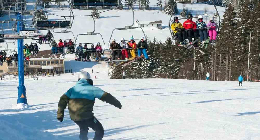 Winter scene at Brookvale Ski Park, featuring a skier on the hill and the chair lift transporting more skiers