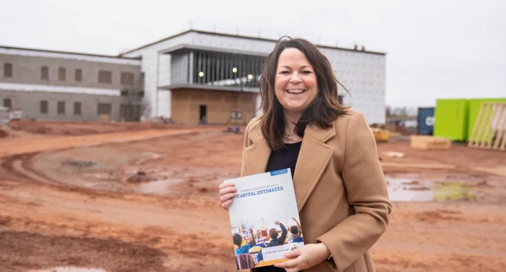image of a person holding a document while standing in front of a building under contruction
