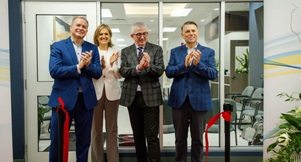 image of four people clapping their hands after a ribbon cutting ceremony