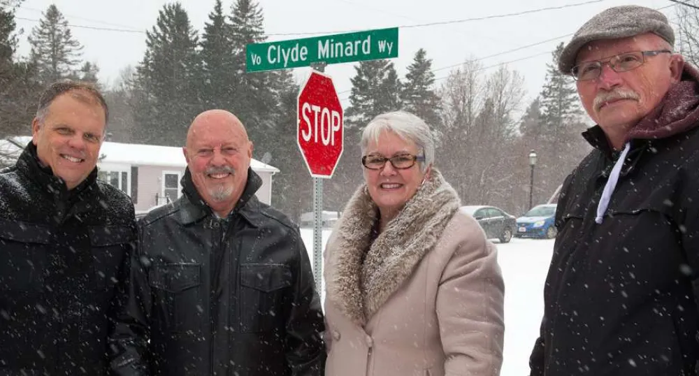 Street named after Tyne Valley leader Minister Biggar and thre other people stand in front of the Clyde Minard Way street sign.