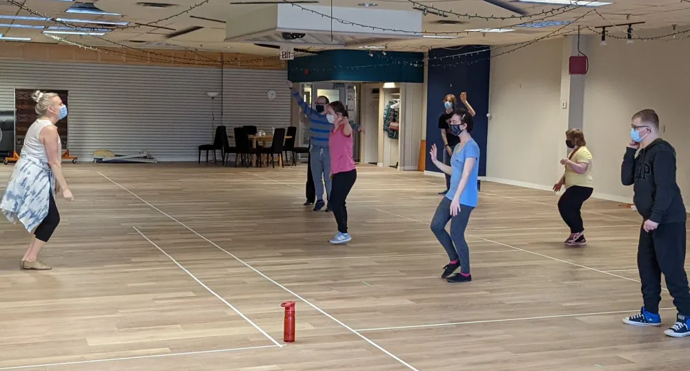 Woman instructing dance students 