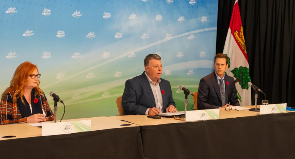 image of three people sitting at a table with microphones in front of them
