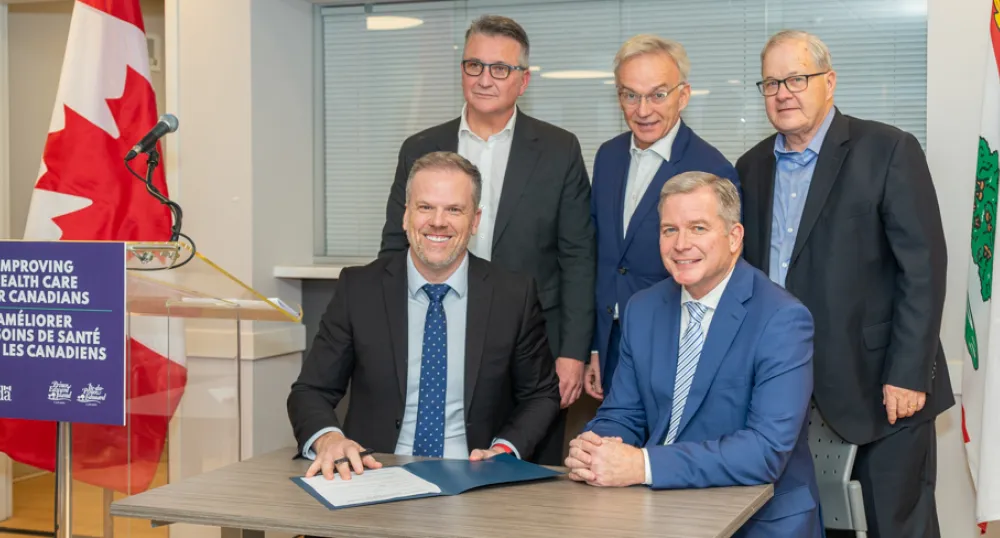 Canada signs $94 million bilateral agreement with Prince Edward Island to improve health care over three years image of five people at a table signing a document