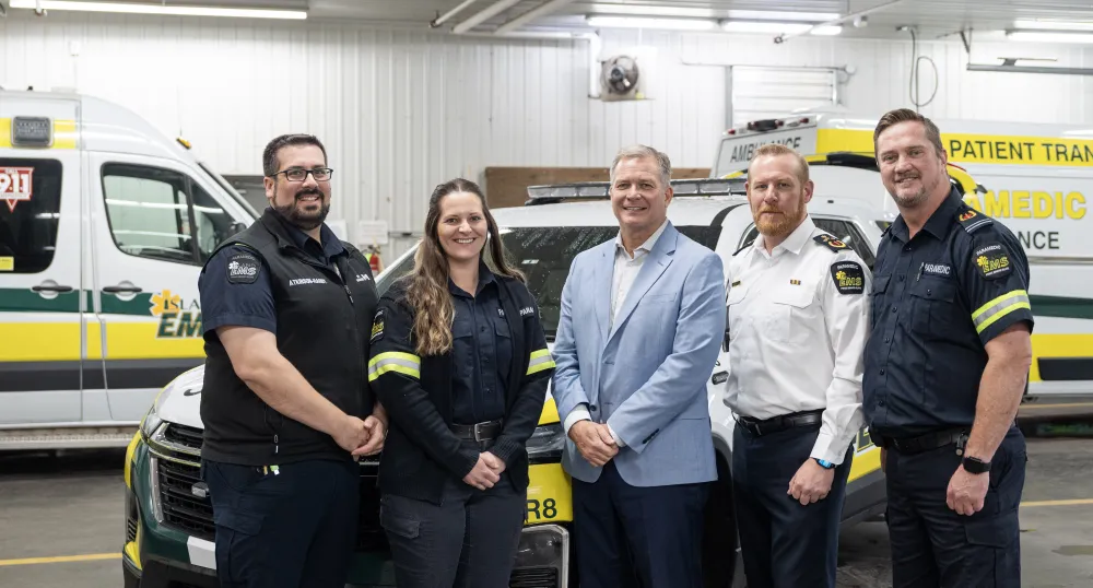 EMS workers and the Minister pictured in front of EMS vehicles