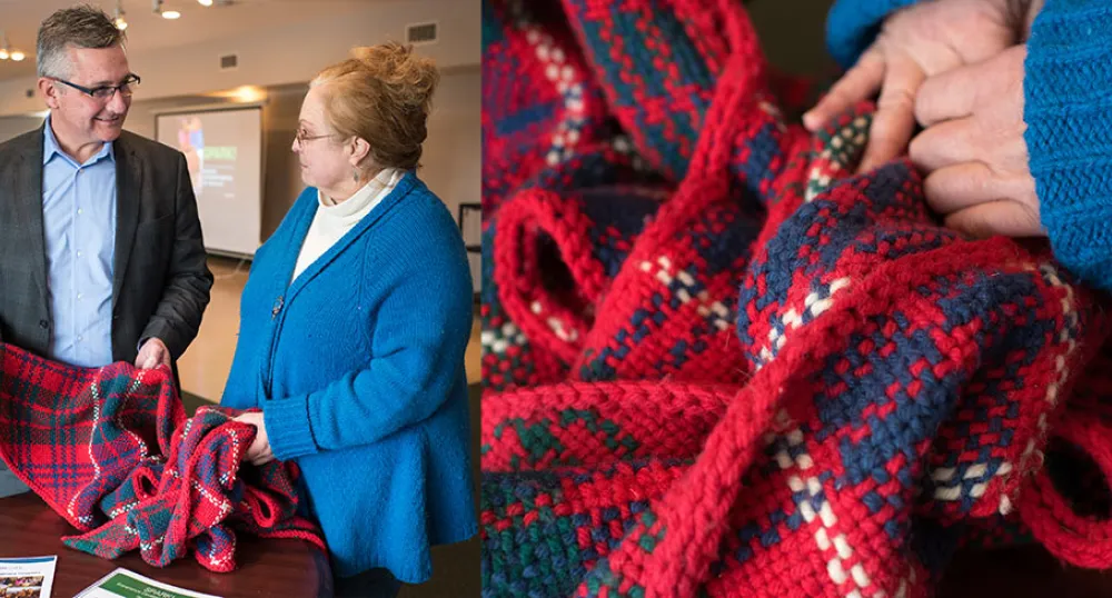 Two people holding a quilt