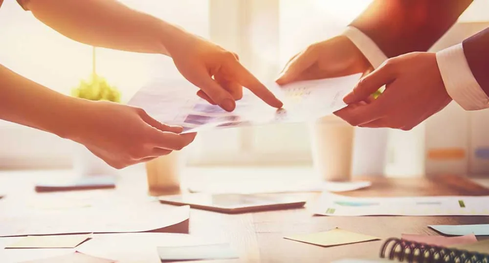 Photo shows people handing each other papers