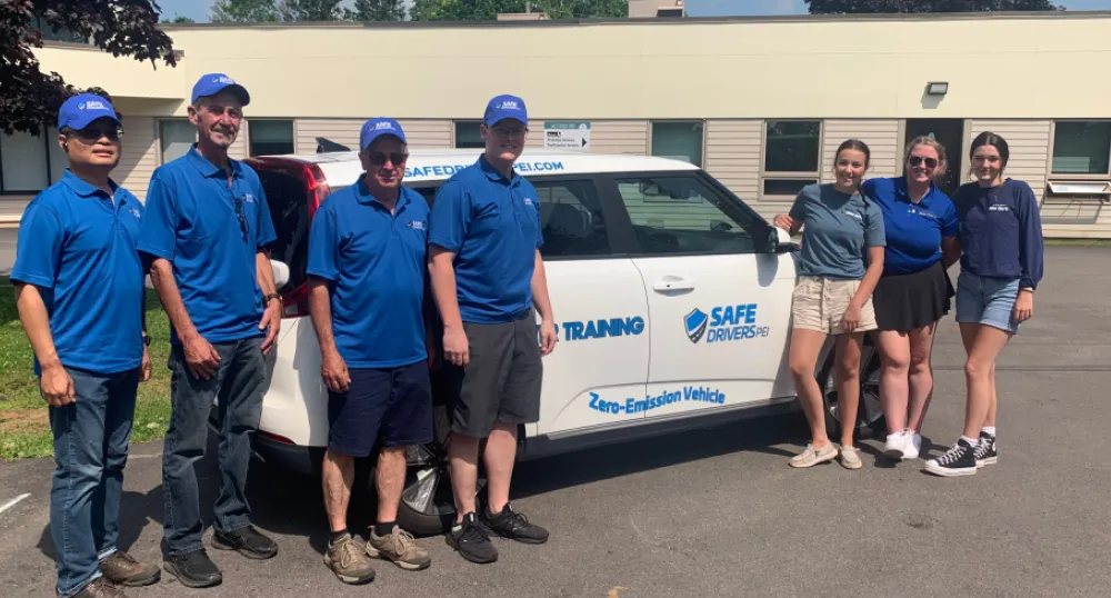 Getting the feel for an electric vehicle image of people standing in front of a new electric vehicle with a building in the background