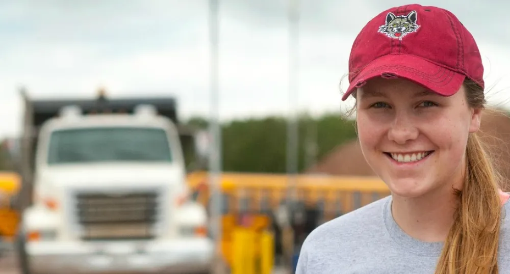Young woman standing with a provincial truck in the background