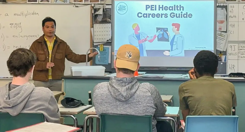 Some students sit in a classroom listening to the presentation