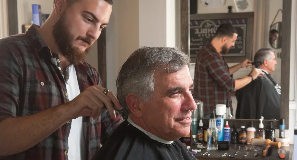 The Humble Barber suceeds with help from Self Employ PEI Minister Richard Brown is sitting in a barber chair having his haircut at The Humble Barber