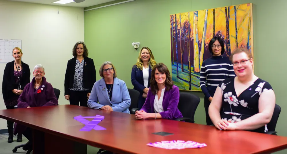 Community groups receive funding to help prevent violence against women image of people sitting at a large table in a boardroom