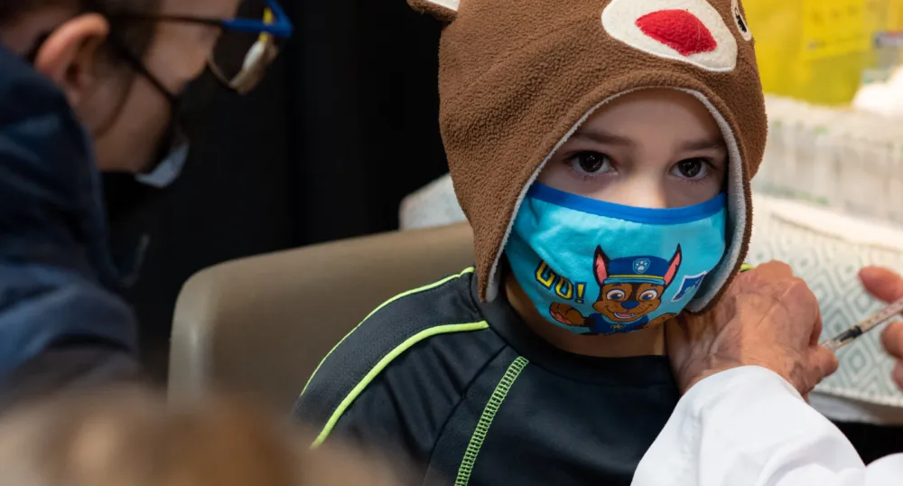 First vaccine clinic held for children age 5 to 11; two new cases of COVID-19 image of a child with a mask on receiving his vaccination