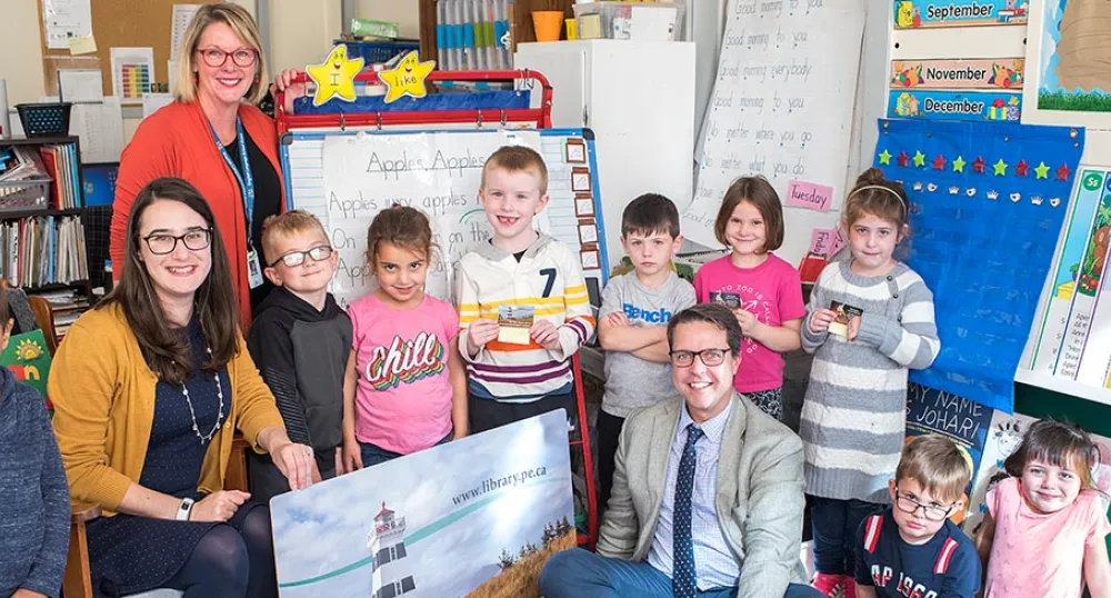a group of adults and children in a classroom