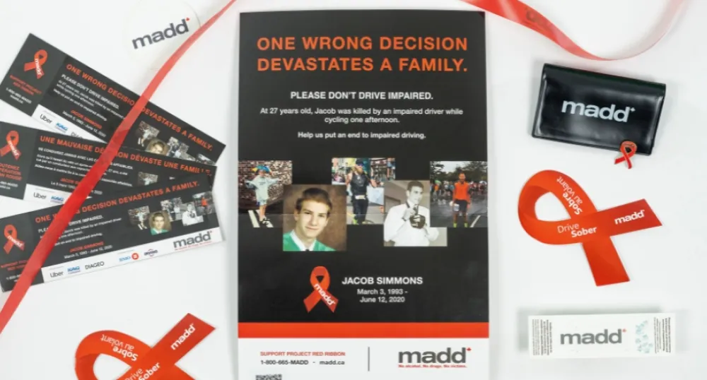 Province, MADD Canada and RCMP join forces against impaired driving image of a poster with red ribbon and brochures on both side of it