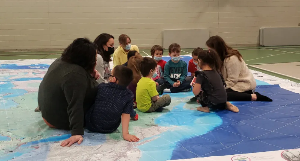 Teachers sitting on the floor with students