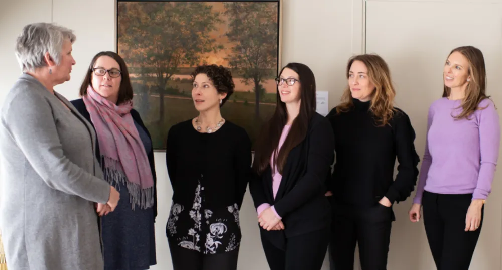Minister Compton standing speaking to four women about the new booklet