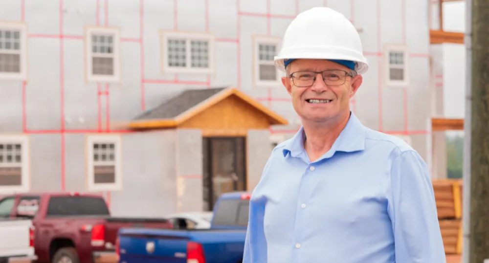 More investments in housing support for Islanders Man in a hard hat standing in front of a building under construction