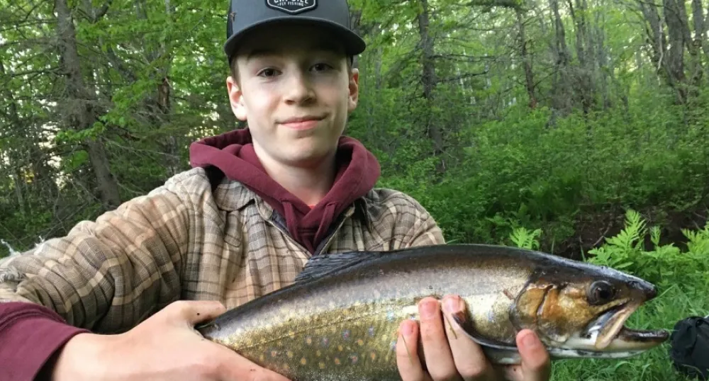 Permis de pêche disponibles dès maintenant image d'un garçon tenant un poisson devant son corps