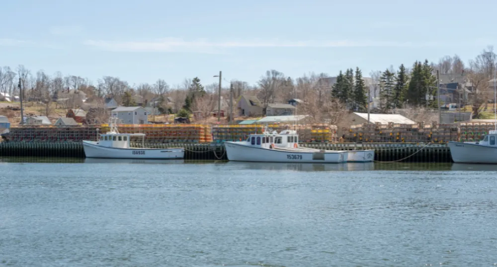 image of  fishing tied up at a dock with lobster traps on the wharf
