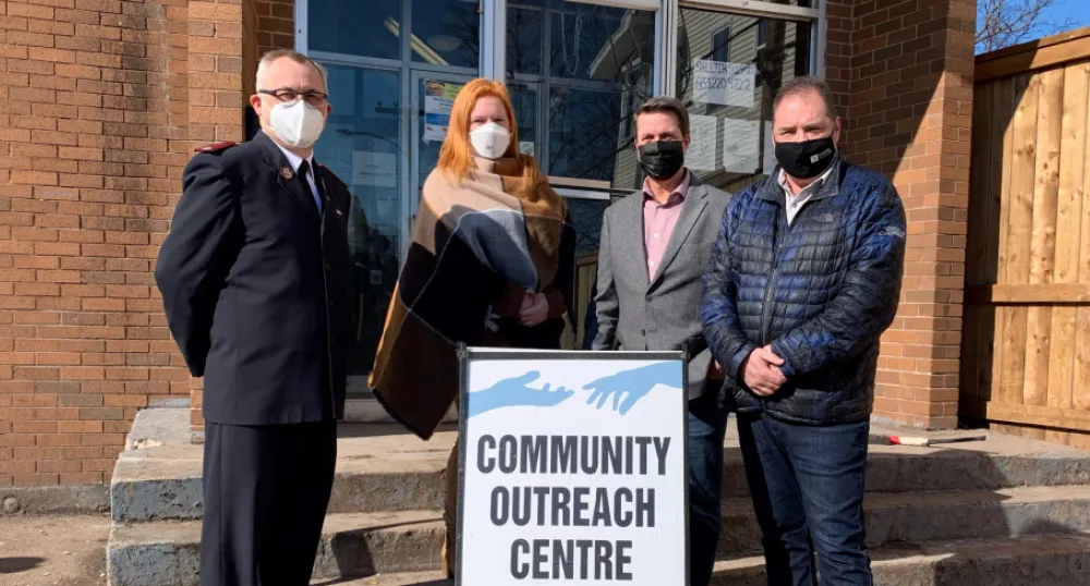 Province announces new operator of the Community Outreach Centre image of four people standing shulder to shoulder in front of steps of a building