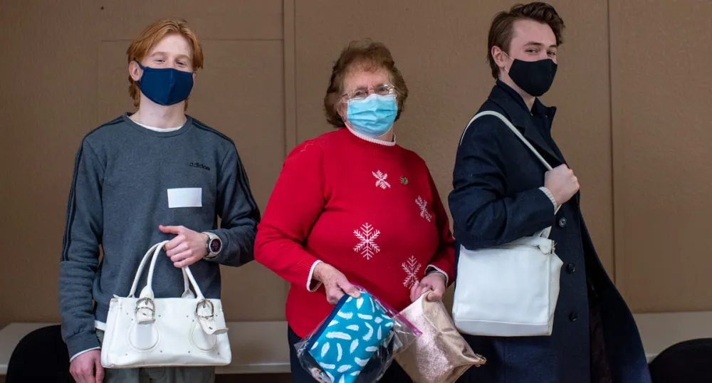 two boys and a senior holding bags