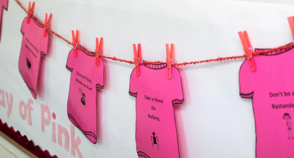 A line of pink shirt cut-outs to promote kindness on Pink Shirt Day