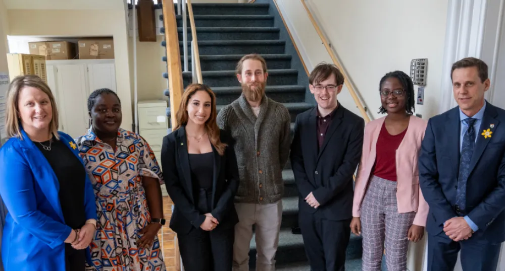 Provincial grants for student housing study image of people standing shoulder to shoulder in a building at the bottom of stairs
