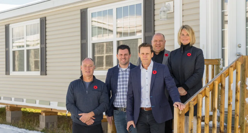 Province launches Rent-to-Own program image of five people standing on steps in front of a mini home