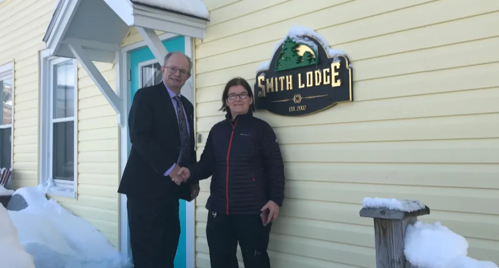 More transitional housing support for Islanders Two people standing in front of a house
