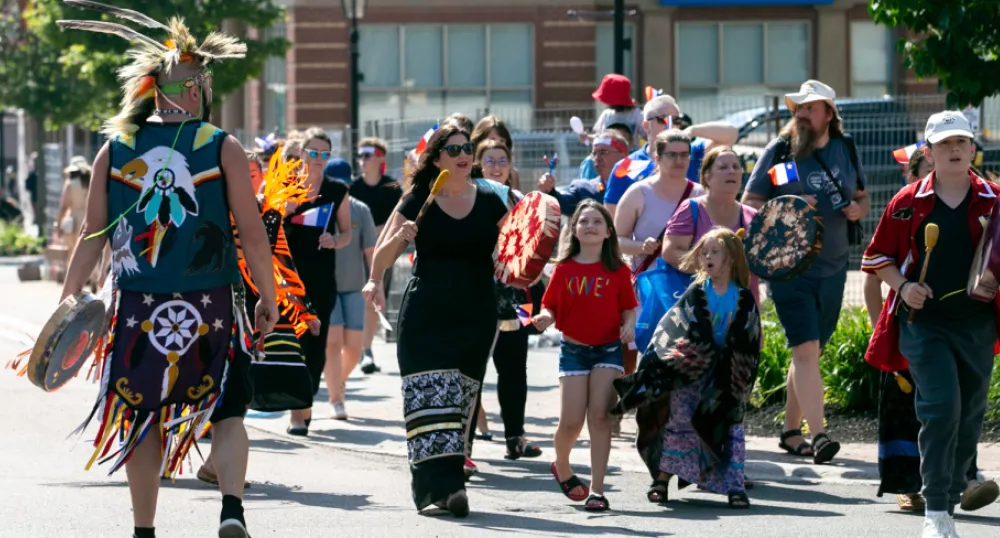 A tintamarre parade of people celebrating National Acadian Day in Charlottetown