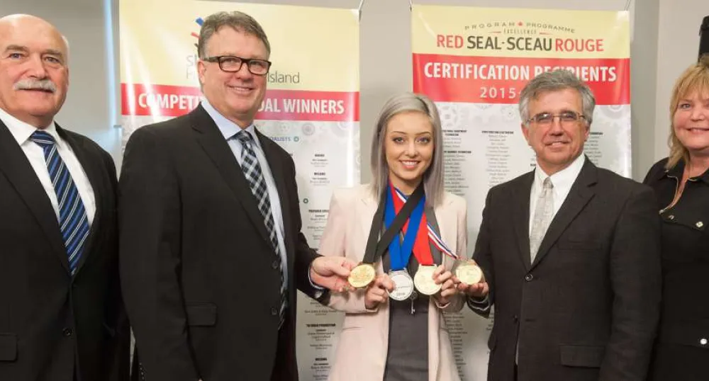 Week focuses on careers, trades and technology People standing in front of pop-up banners with middle person displaying medals won at a national competition.