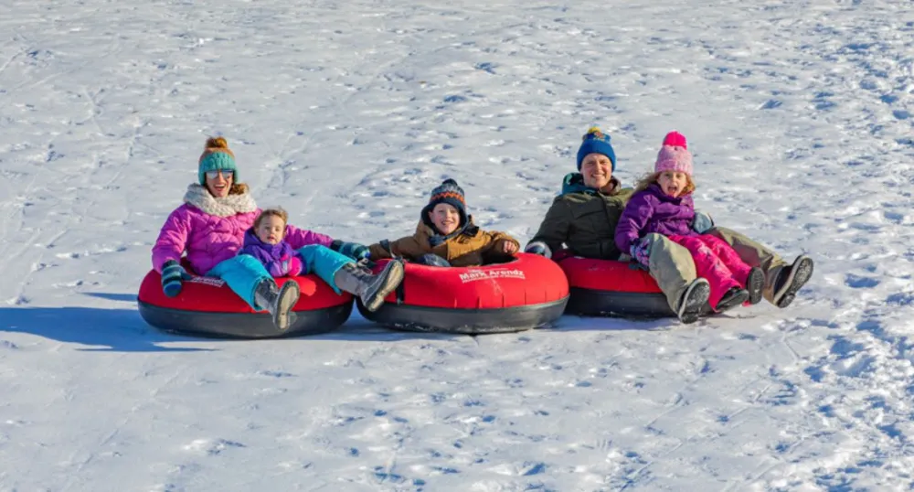 Image of family in tubes on snowy hill